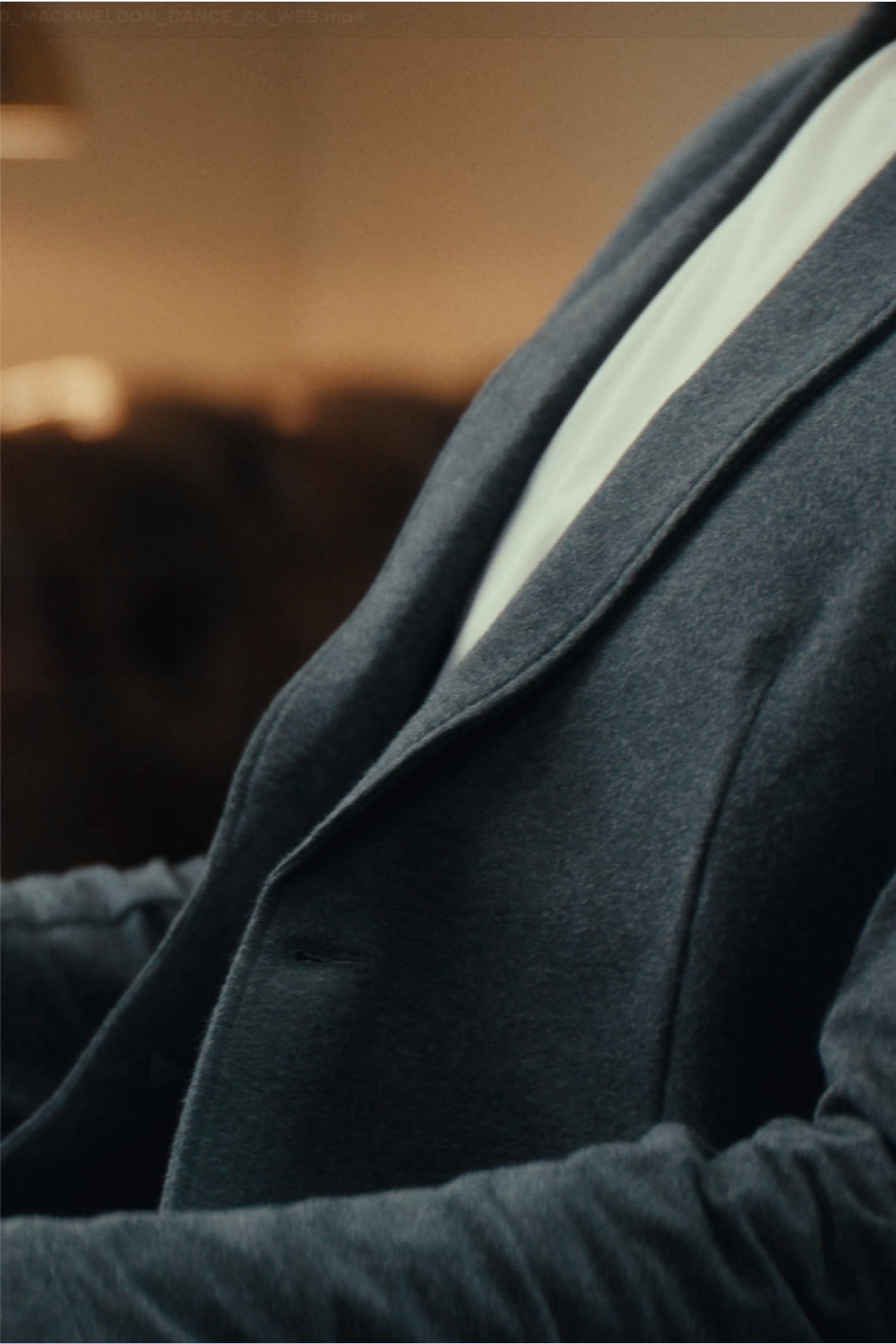 Close up of a man sitting in a chair wearing a comfortable looking blazer